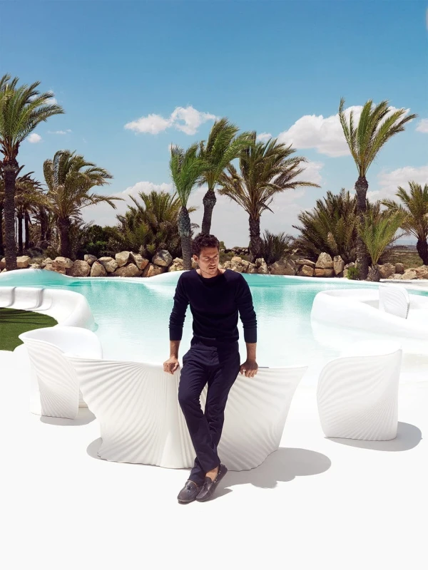 Biały fotel Vondom Biophilia przy basenie wśród palm