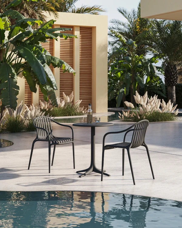 Czarne krzesła Vondom Palm przy stoliku nad basenem w hotelowym patio