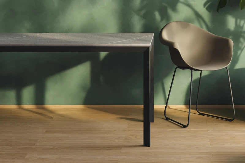 Ciemny stół Frame Vondom przy zielonej ścianie z krzesłem