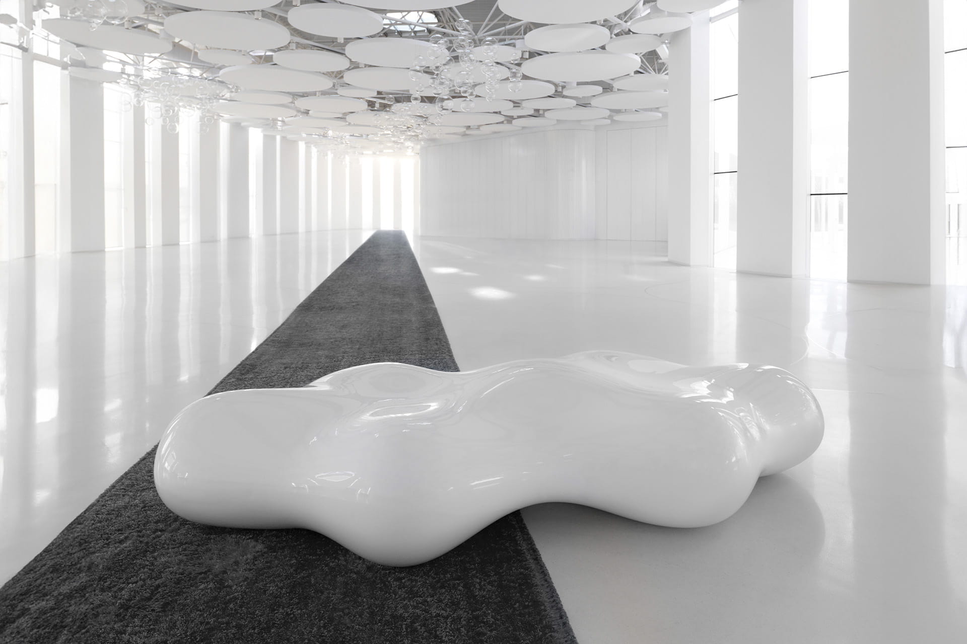 Biała ławka Vondom Lava w jasnym, przeszklonym atrium